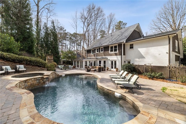 view of swimming pool featuring a patio, french doors, fence, and a pool with connected hot tub