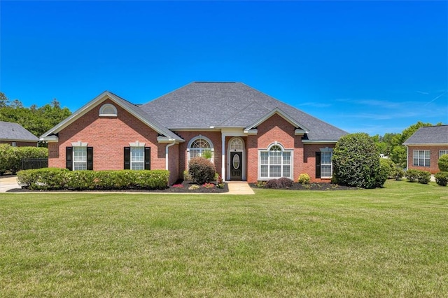 view of front of house featuring brick siding and a front lawn