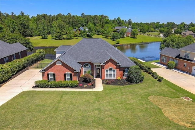 view of front facade with brick siding, concrete driveway, and a water view