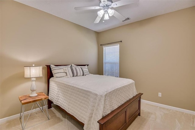 bedroom featuring baseboards, light colored carpet, and a ceiling fan
