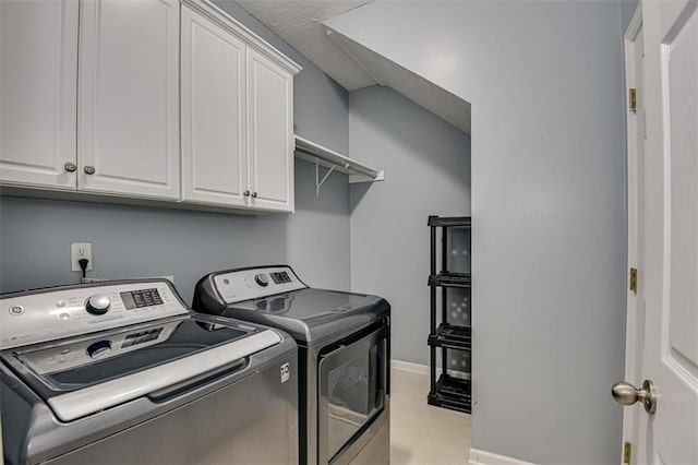 laundry area with washing machine and dryer, cabinet space, and baseboards