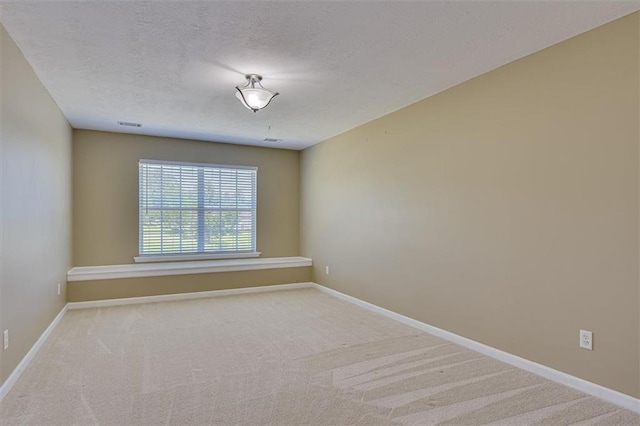 unfurnished room featuring carpet flooring, baseboards, and a textured ceiling