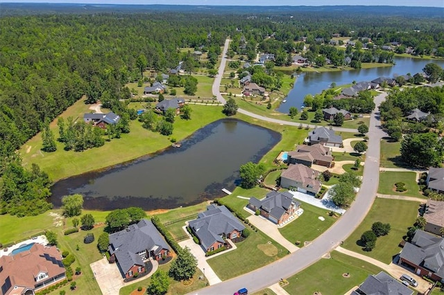 aerial view of property's location with a heavily wooded area, a large body of water, and nearby suburban area