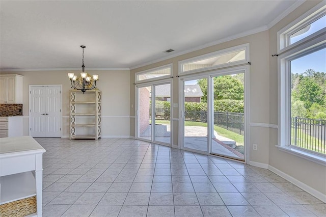 unfurnished dining area with light tile patterned floors, a chandelier, crown molding, and baseboards