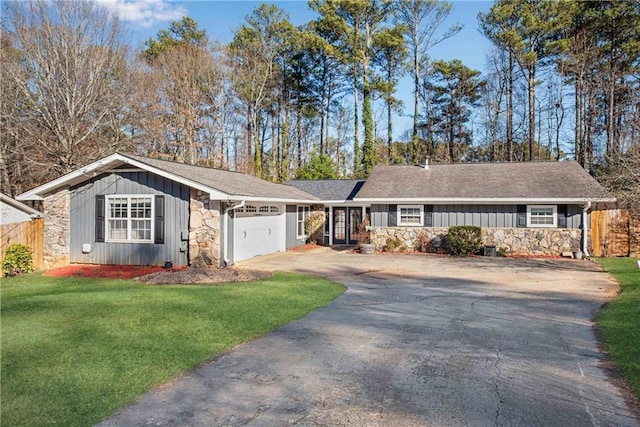 single story home with a garage and a front lawn