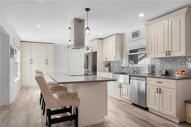 kitchen with a kitchen island, decorative light fixtures, sink, island exhaust hood, and stainless steel appliances