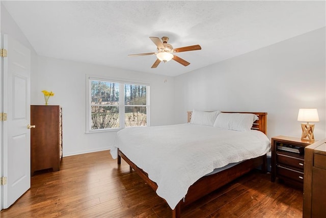 bedroom with dark hardwood / wood-style flooring and ceiling fan