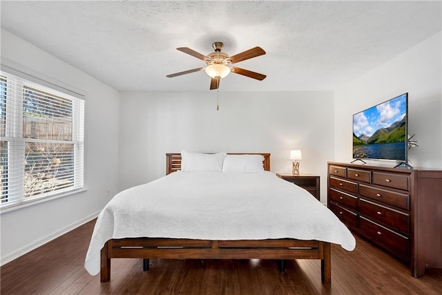 bedroom featuring ceiling fan, dark hardwood / wood-style flooring, and a textured ceiling