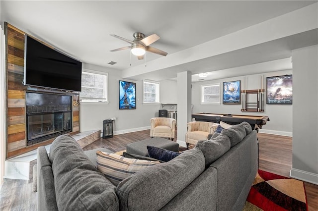 living area with visible vents, baseboards, a glass covered fireplace, wood finished floors, and pool table