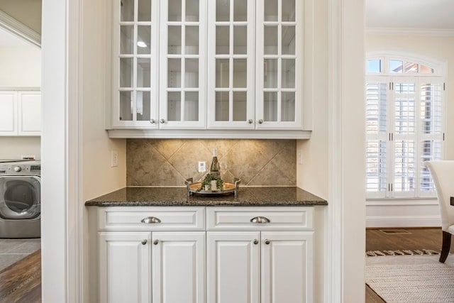 bar featuring washer / dryer, ornamental molding, decorative backsplash, and wood finished floors