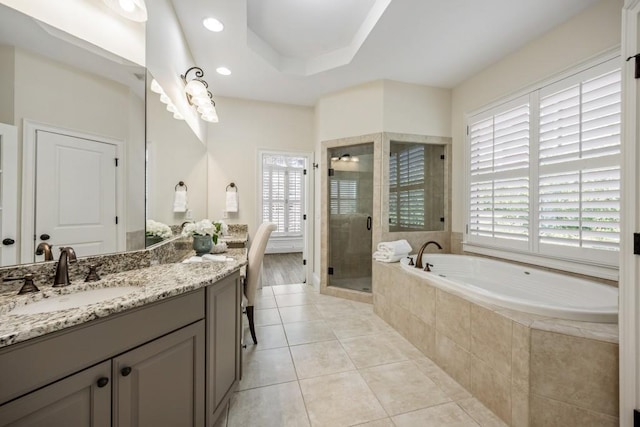 full bathroom with a raised ceiling, a stall shower, vanity, tile patterned flooring, and a bath