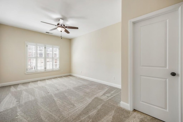 carpeted empty room with a ceiling fan, visible vents, and baseboards