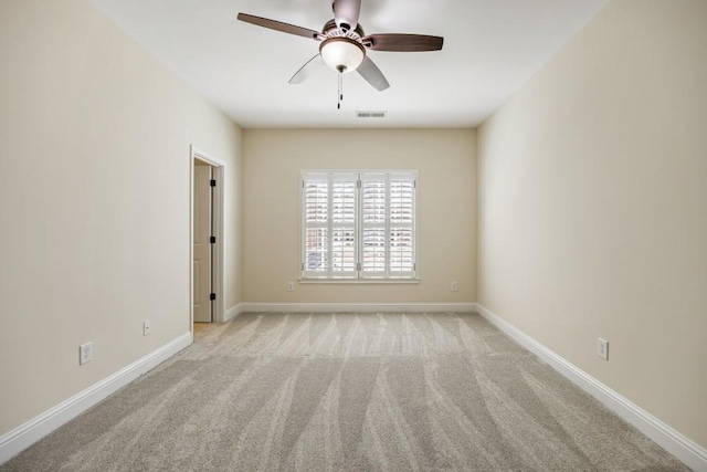 unfurnished room with carpet, visible vents, ceiling fan, and baseboards