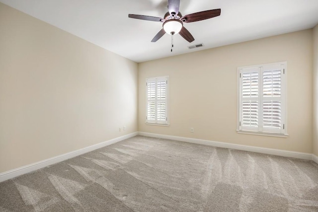 spare room with ceiling fan, carpet, visible vents, and baseboards