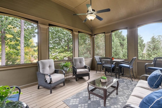 sunroom with a ceiling fan, lofted ceiling, wooden ceiling, and a healthy amount of sunlight