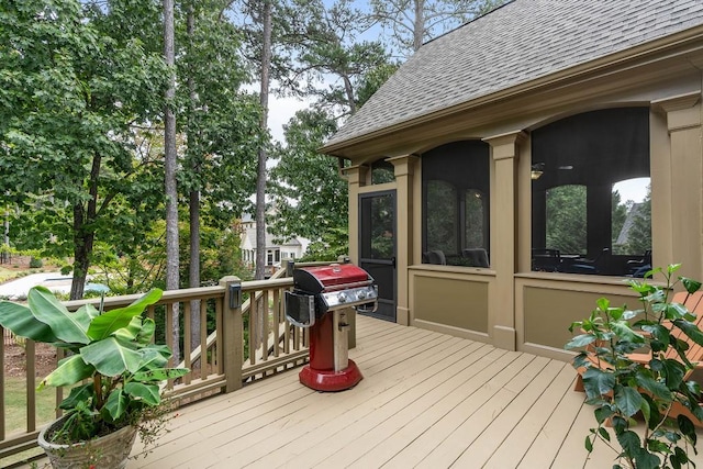 wooden deck with a grill and a sunroom