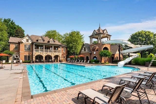 pool with a water slide and a patio area