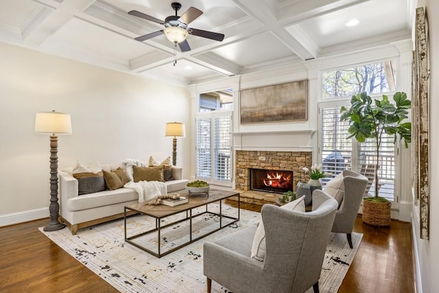 living room featuring a stone fireplace, coffered ceiling, wood finished floors, and beamed ceiling