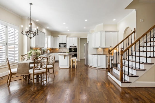 dining area with dark wood-style floors, stairs, and a notable chandelier