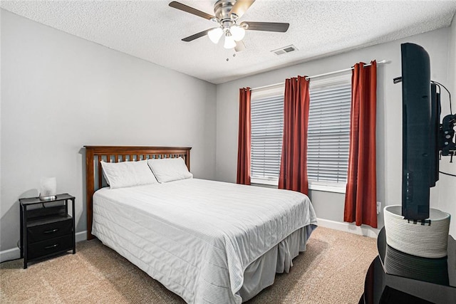 bedroom featuring baseboards, a textured ceiling, visible vents, and light colored carpet