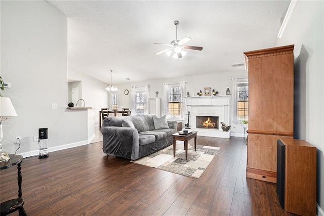 living area with dark wood-style flooring, a healthy amount of sunlight, and a fireplace