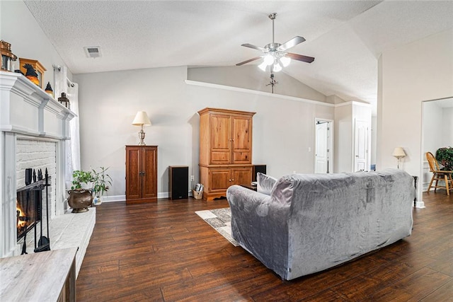 living area featuring a brick fireplace, visible vents, vaulted ceiling, and dark wood-style flooring