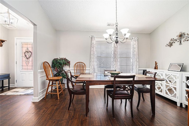 dining room featuring a chandelier, a textured ceiling, visible vents, baseboards, and hardwood / wood-style floors