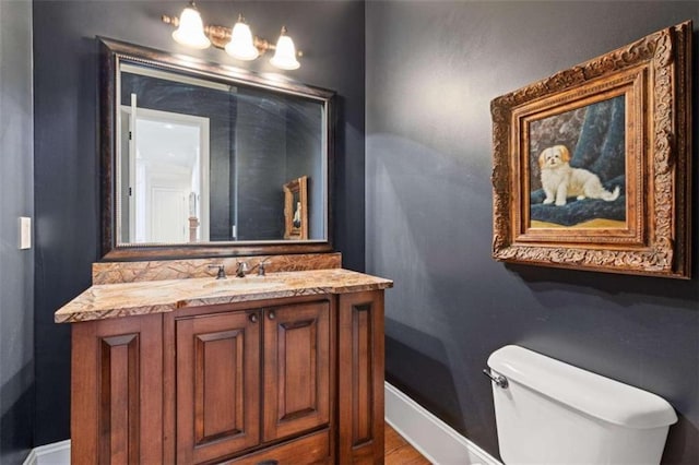 bathroom with wood-type flooring, vanity, and toilet