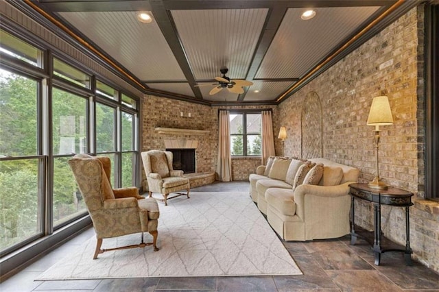 living room with ceiling fan, plenty of natural light, and a large fireplace