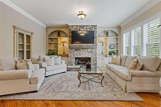 living room featuring ornamental molding, light hardwood / wood-style floors, and a stone fireplace