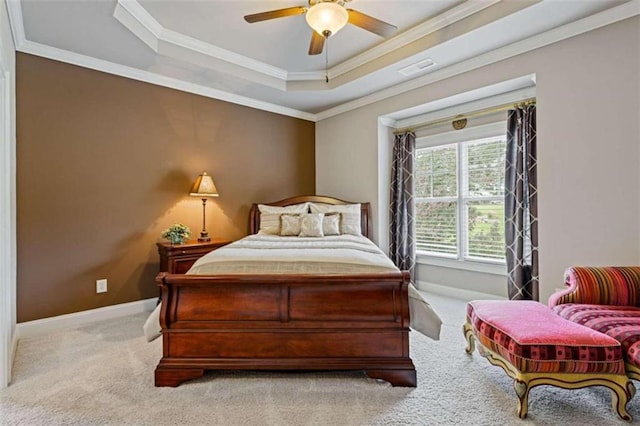 carpeted bedroom featuring ceiling fan, a tray ceiling, and ornamental molding