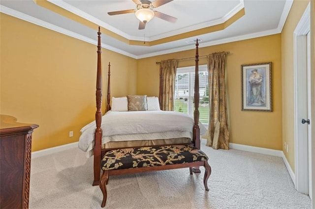 carpeted bedroom with a raised ceiling, ornamental molding, and ceiling fan