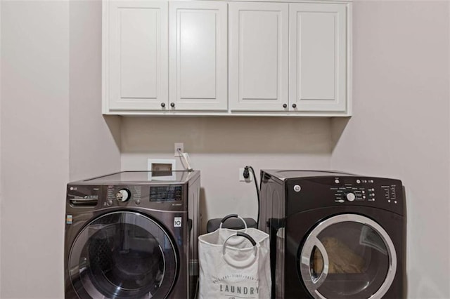 laundry room with washer and clothes dryer and cabinets