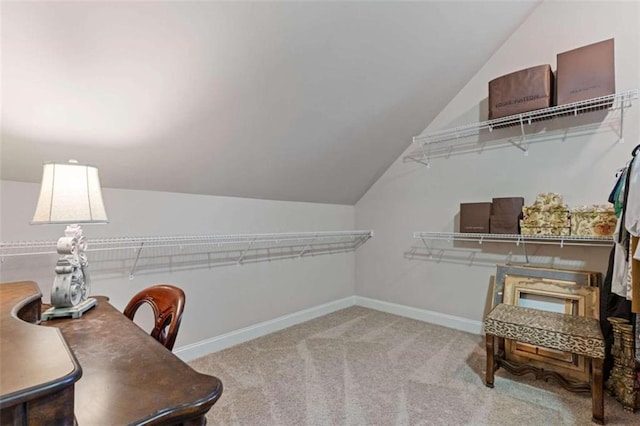 walk in closet featuring light colored carpet and lofted ceiling