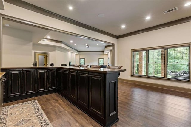 kitchen featuring kitchen peninsula, dark hardwood / wood-style floors, and crown molding