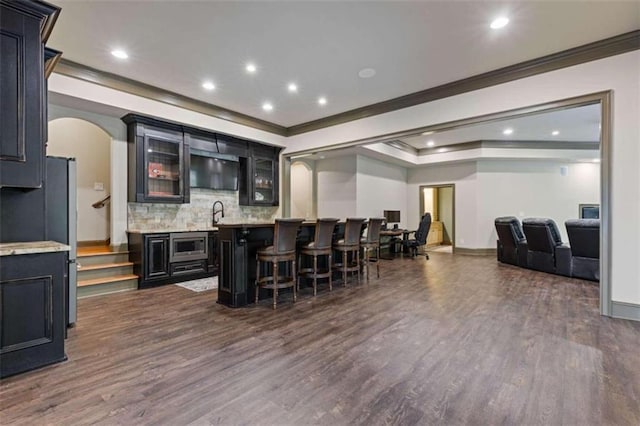 bar with appliances with stainless steel finishes, crown molding, and dark wood-type flooring