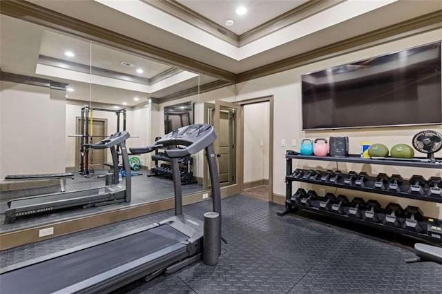 gym featuring a tray ceiling and crown molding