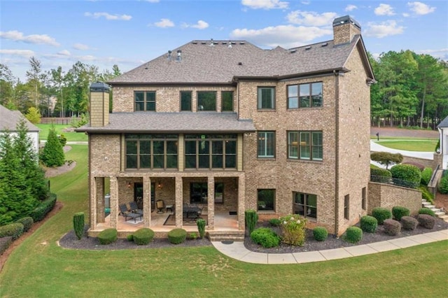 back of property with a lawn and a patio