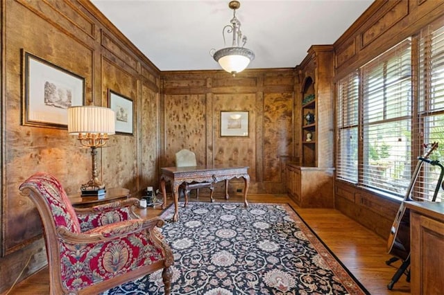 office space featuring light hardwood / wood-style flooring, a wealth of natural light, wood walls, and a chandelier