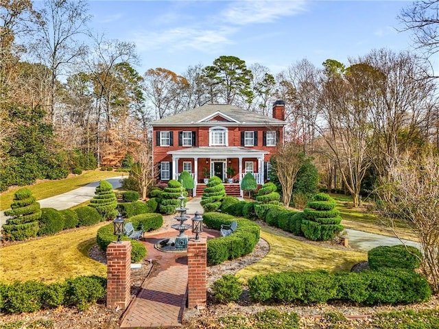 306 Calumet Ln, Monroe, GA 30655 - colonial house featuring a chimney and covered porch
