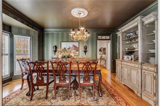306 Calumet Ln, Monroe, GA 30655 - dining room with a chandelier, light wood-style floors, crown molding, and wallpapered walls