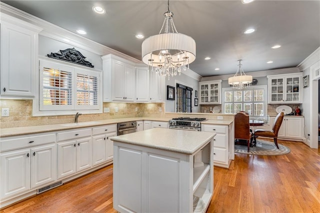 306 Calumet Ln, Monroe, GA 30655 - kitchen featuring a sink, a chandelier, ornamental molding, a peninsula, and a center island