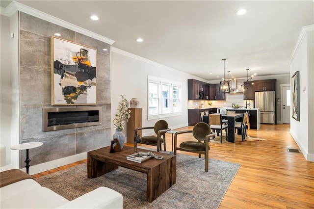 1354 Mcpherson Ave SE, Atlanta, GA 30316 - living area featuring light wood-style flooring, ornamental molding, recessed lighting, a chandelier, and a tiled fireplace