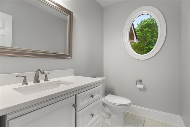 bathroom featuring toilet, vanity, tile patterned floors, and baseboards