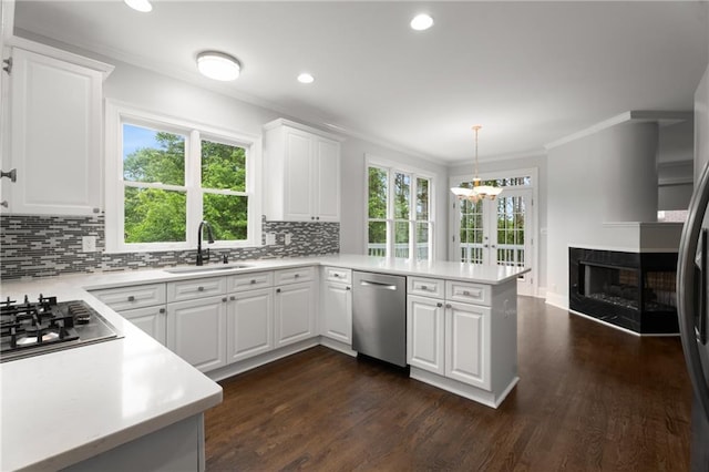 kitchen featuring ornamental molding, a sink, a peninsula, and stainless steel appliances