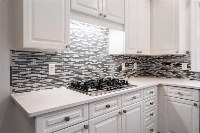 kitchen featuring white cabinetry, stainless steel gas cooktop, and backsplash