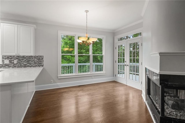 unfurnished dining area with crown molding, a chandelier, french doors, visible vents, and wood finished floors