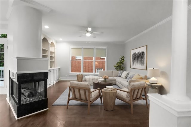 living room featuring a multi sided fireplace, plenty of natural light, a ceiling fan, and crown molding