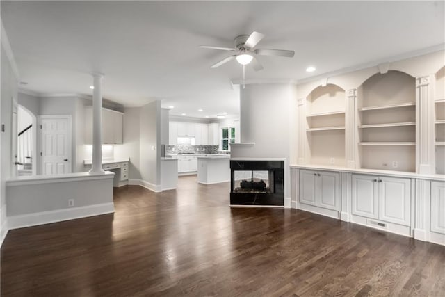unfurnished living room featuring ornate columns, a ceiling fan, dark wood-type flooring, and recessed lighting