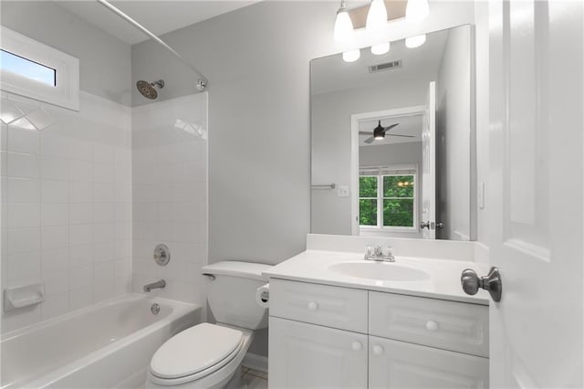 bathroom with vanity, ceiling fan, toilet, visible vents, and tub / shower combination